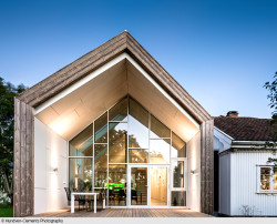 „Ersatz-Neubau“: Das moderne Interieur, das durch den verglasten Giebel sichtbar wird, kontrastiert mit dem scheinbar verwitterten Holz an Dach und Fassade.