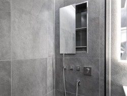 Die Nischenablagebox in der Dusche bietet Stauraum für Shampoo, Duschgel und Co. Architekt Hans-Günther Schwarz hat sich für die Ausführung hochkant mit verspiegelter Schiebetür entschieden. Foto: Geberit