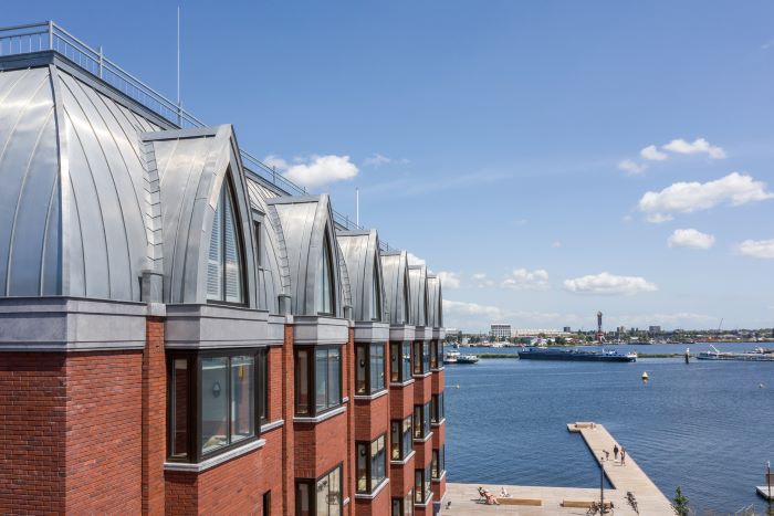 Die Spitzgauben und die leichte Bogenform des Daches erinnern an den Bootsbau, ein wichtiges Spezialgebiet der Niederländer. Foto: RHEINZINK