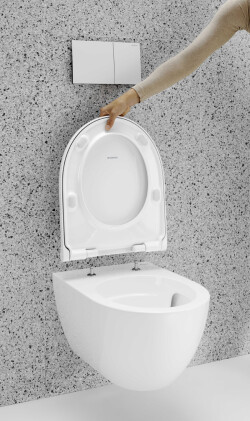 Indem der WC-Sitz um 90 Grad nach oben aufgeklappt wird, kann er mit einem Handgriff abgenommen und wieder aufgesetzt werden. Die QuickRelease-Funktion ist für den Objektbereich blockierbar. Foto: Geberit